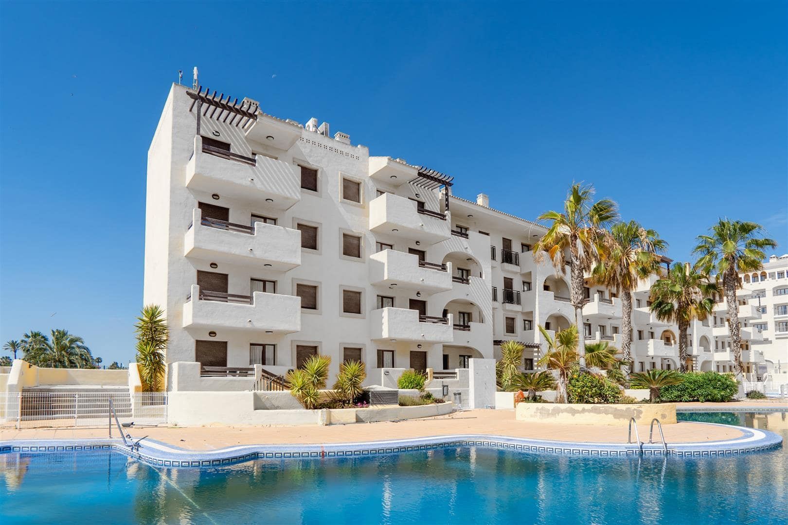 Apartment building and communal swimming pool in daylight