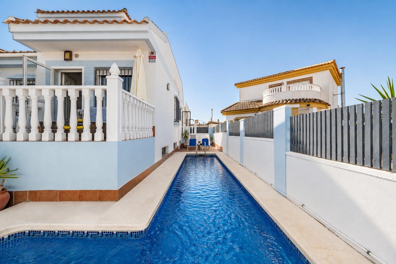 Private pool running along the side of the white villa.