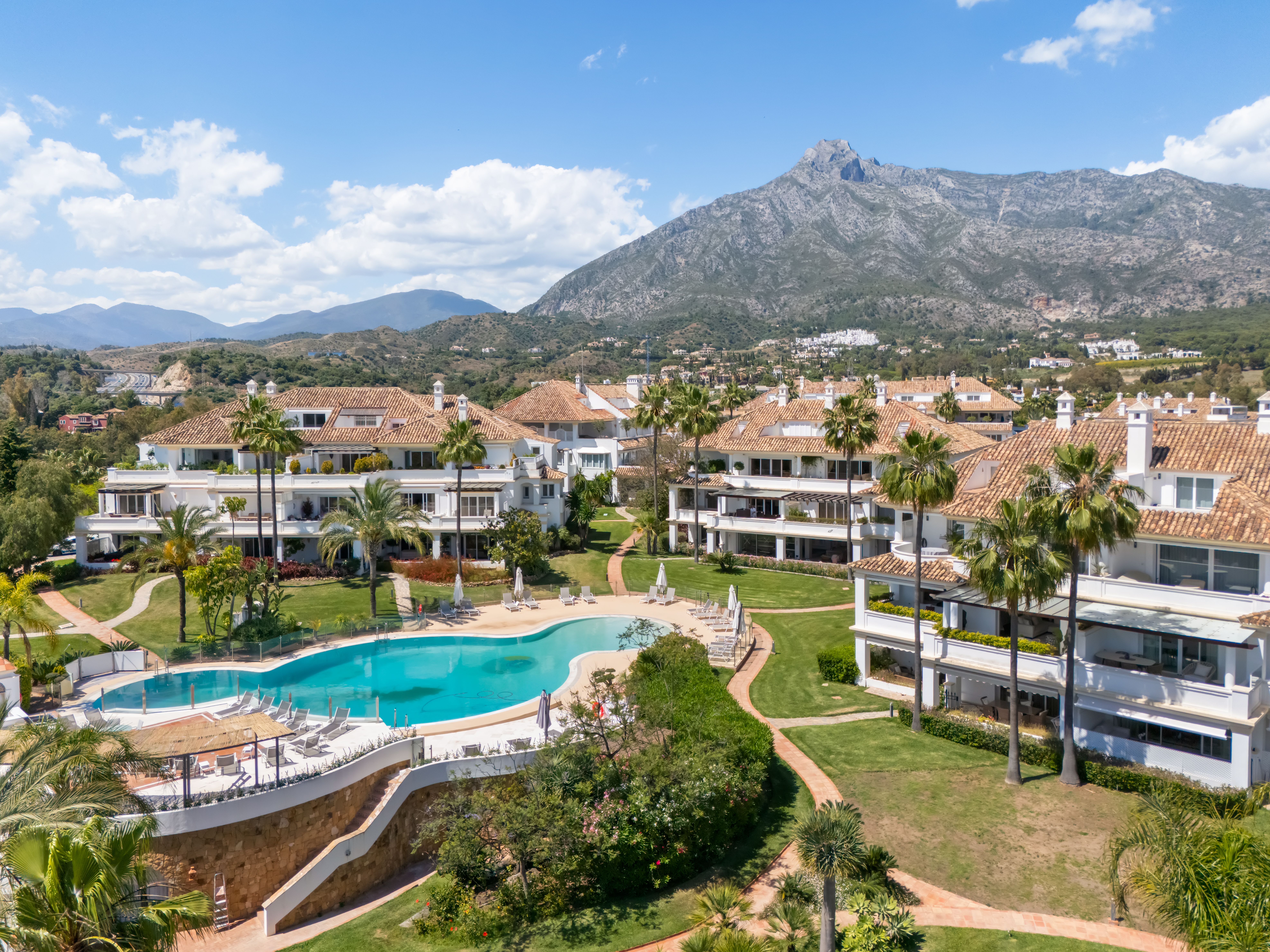 Wide daytime view of the Monte Paraiso pool, gardens and residential buildings