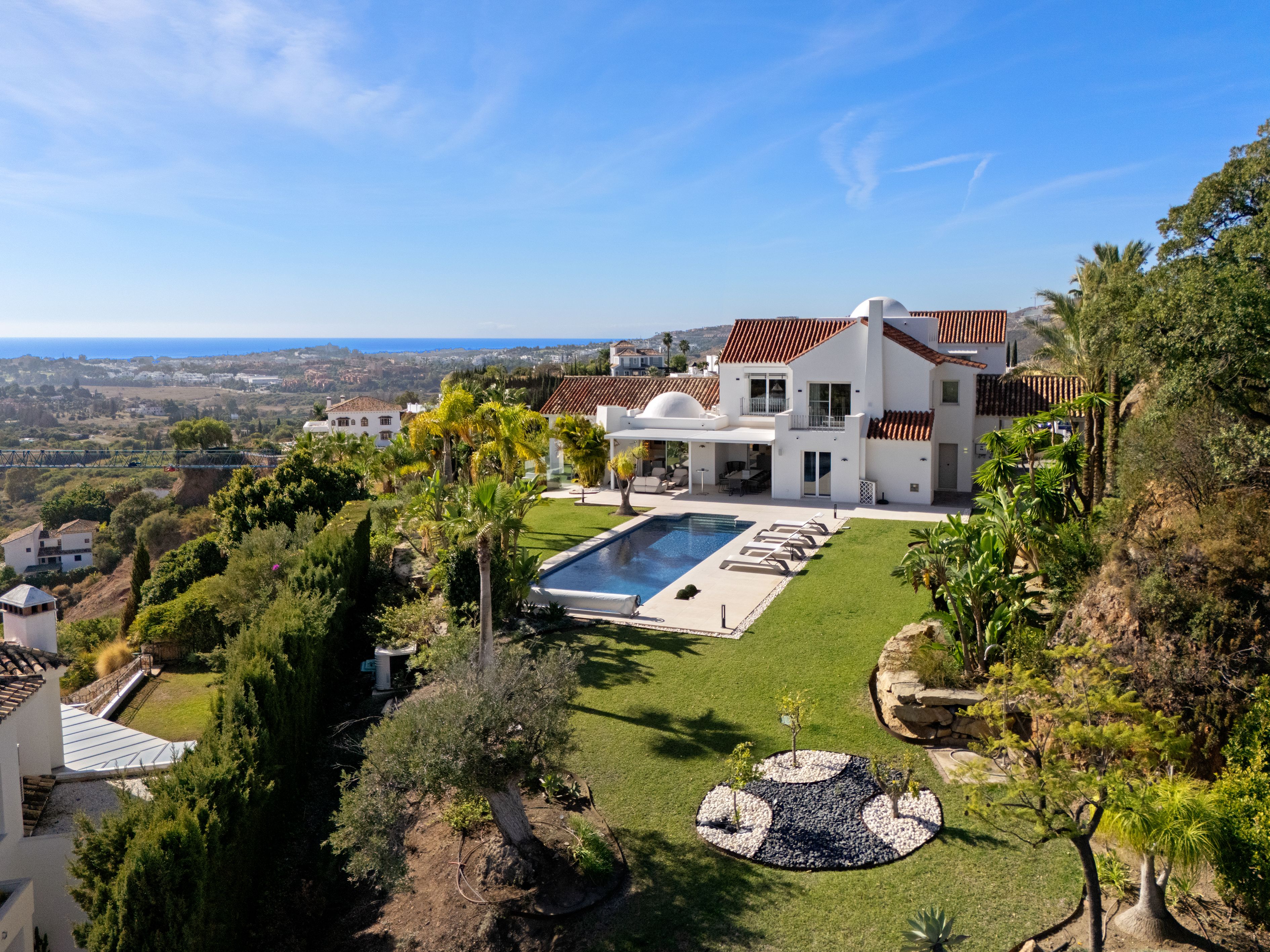 Pool and garden view towards Casa K with loungers and landscaped lawn.