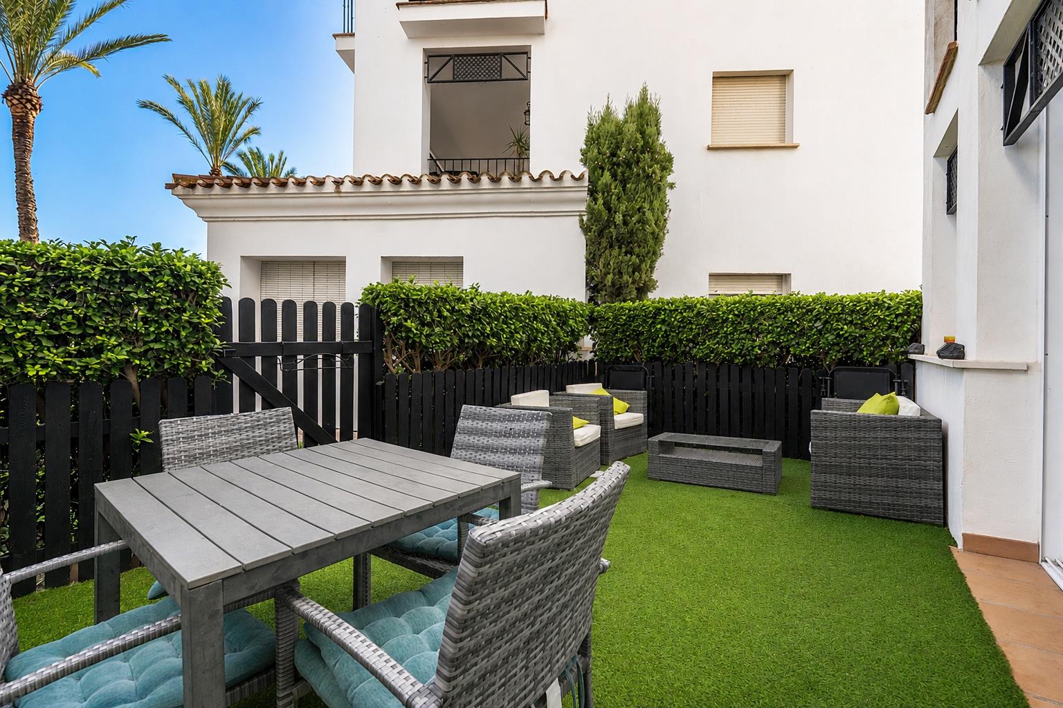 Private garden with outdoor dining and lounge seating beside the apartment.