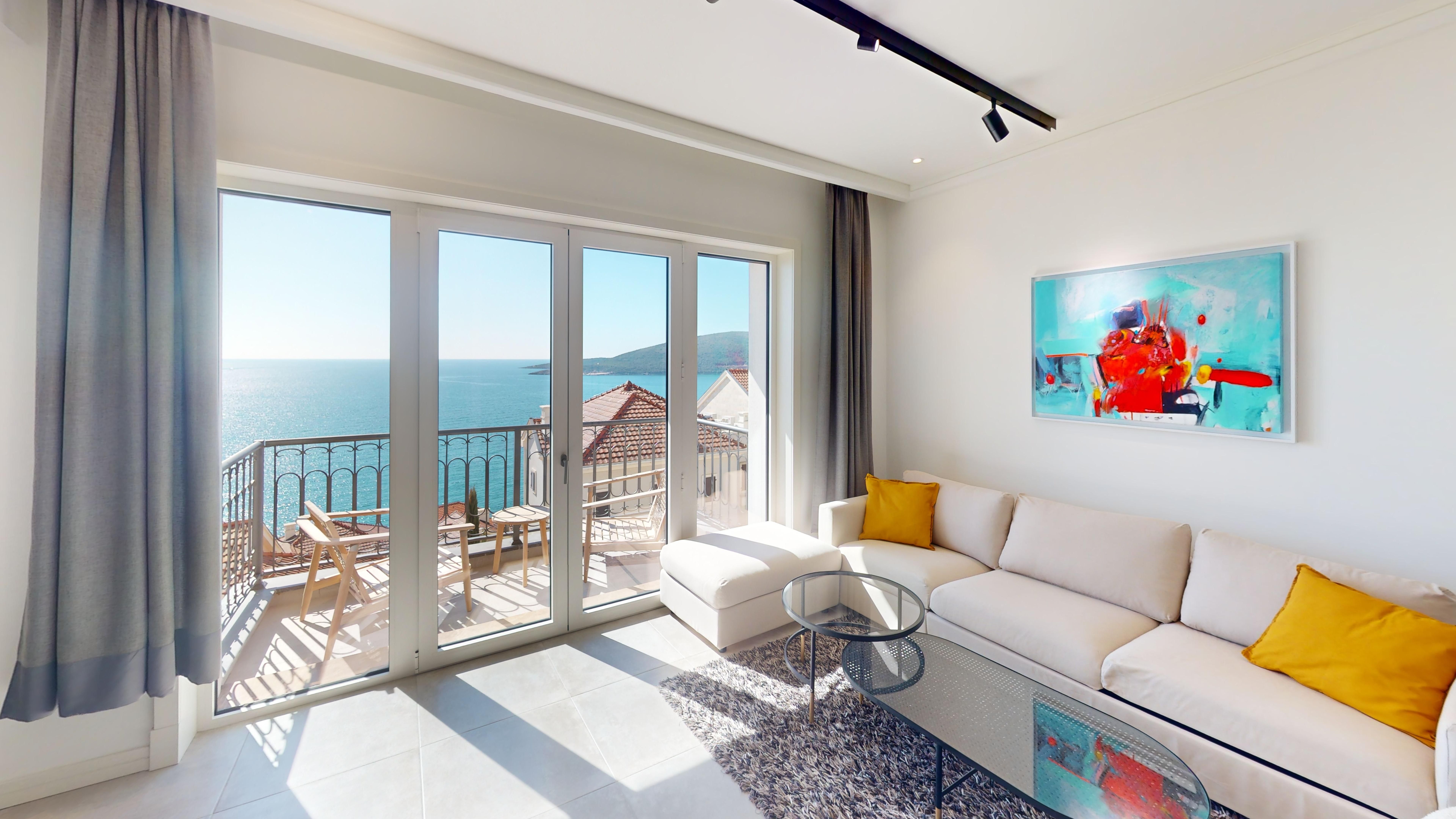 Sea-facing living room opening to the private terrace at Studio I912 in Marina Village, Luštica Bay