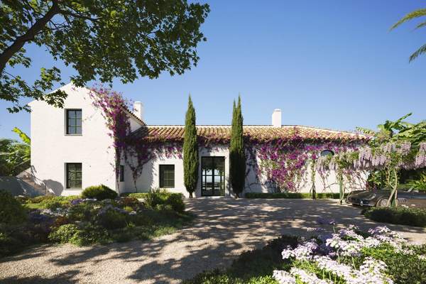 Cortijo 2 entrance facade framed by bougainvillea and Mediterranean planting