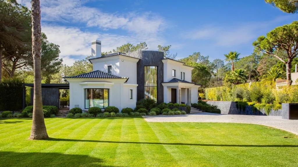 Villa Golfe Norte framed by a lawn, pine trees and landscaped gardens