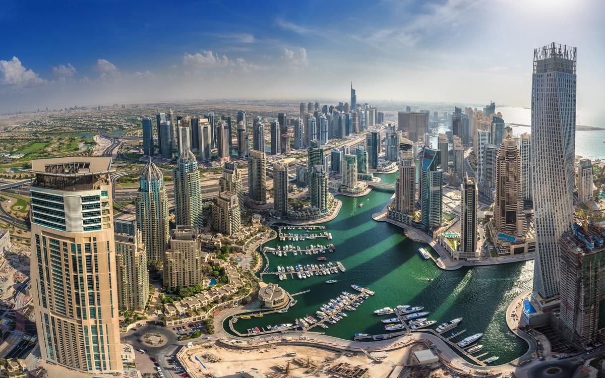 Aerial view of Dubai Marina, with high-rise towers, the marina canal and Sheikh Zayed Road.