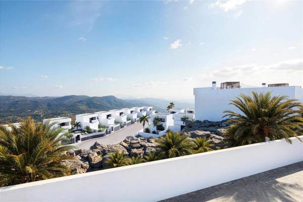 Representative wide rendering across a white villa collection towards distant hills