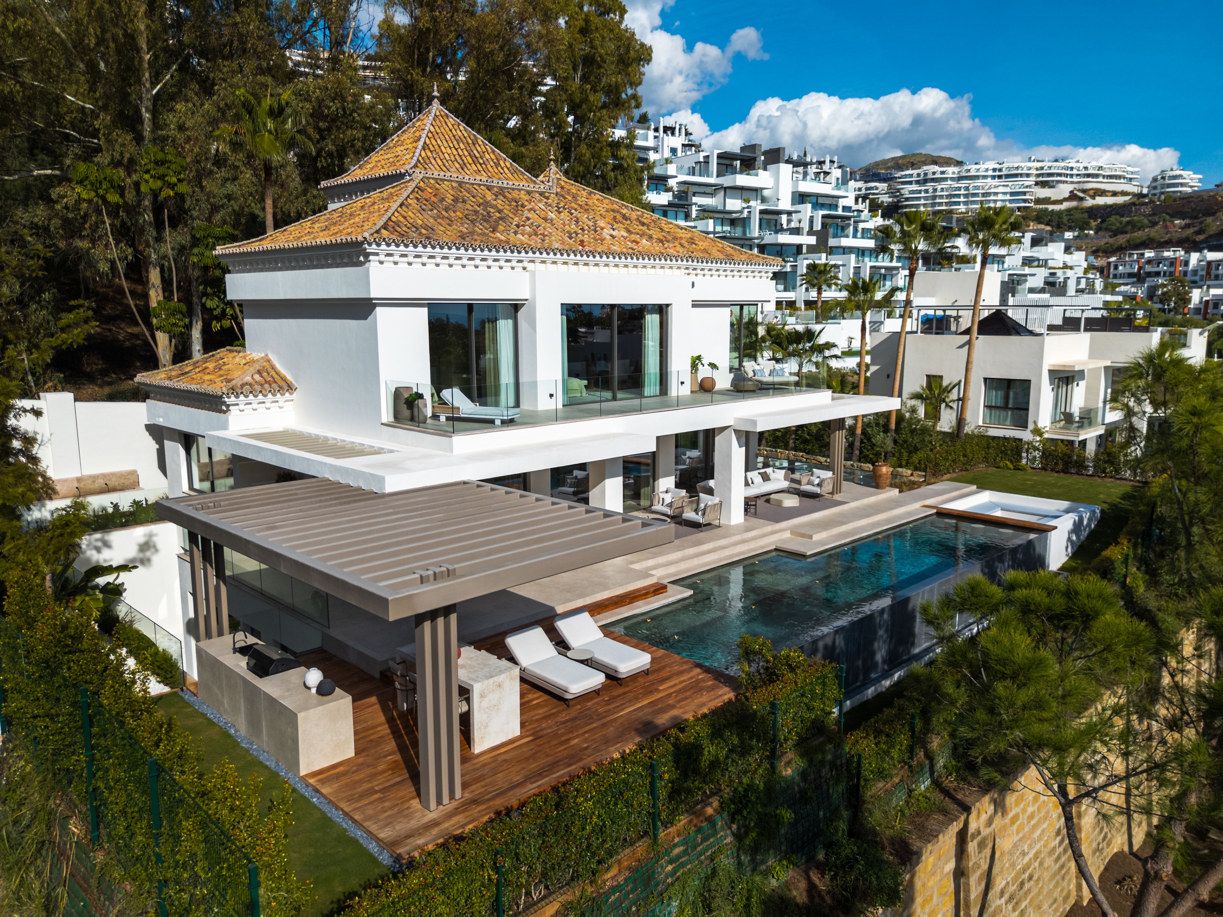 Elevated exterior view of The Ridge villa with infinity pool, terrace and golf-course outlook.