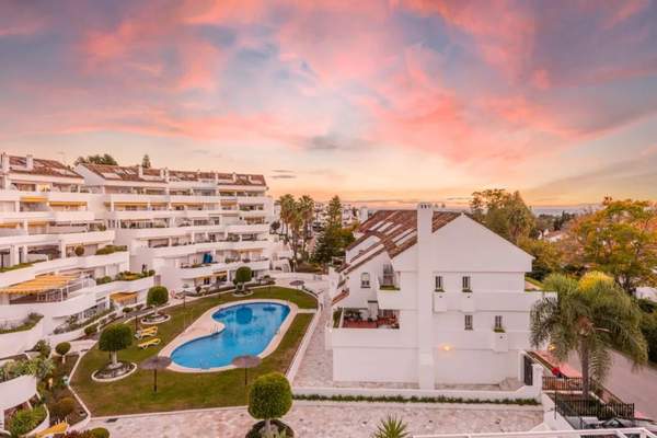 Ocaso Penthouse residential complex and pool beneath a sunset sky