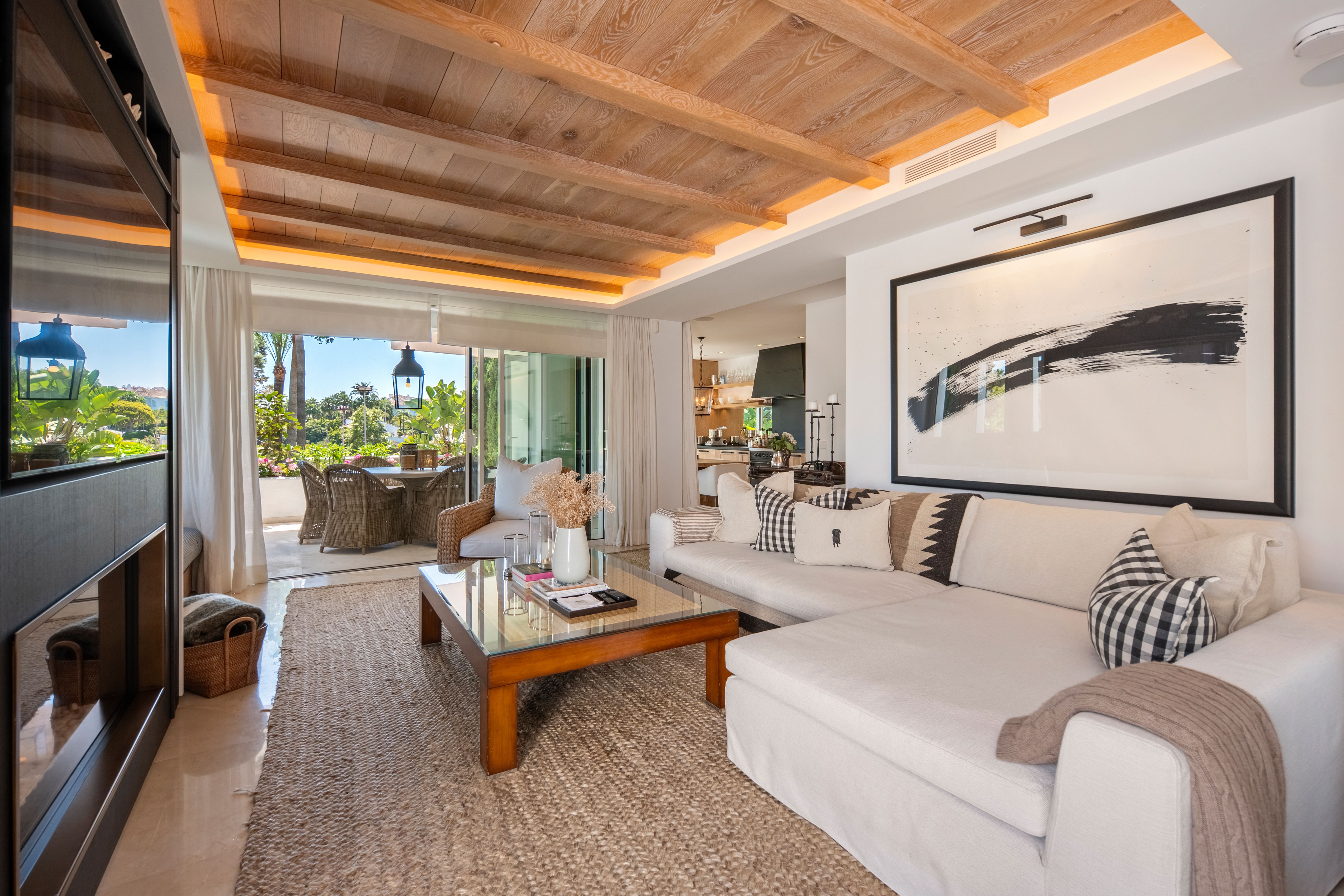 Bright apartment living room opening to the private terrace and garden setting