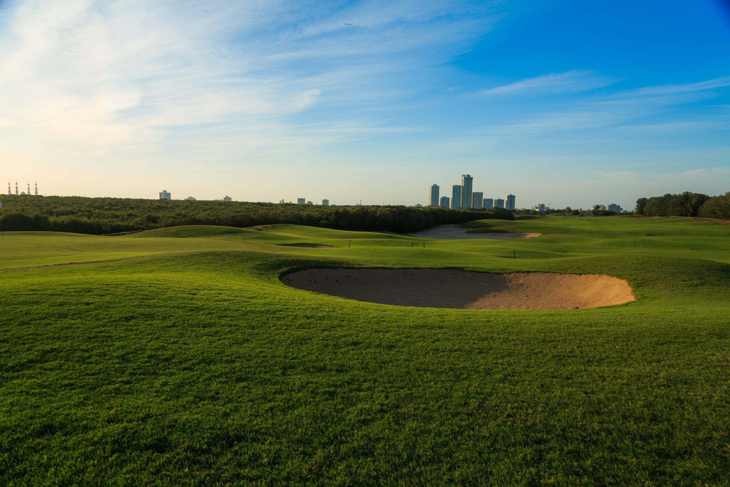 Tower Links Golf Club fairway and bunker with Ras Al Khaimah beyond