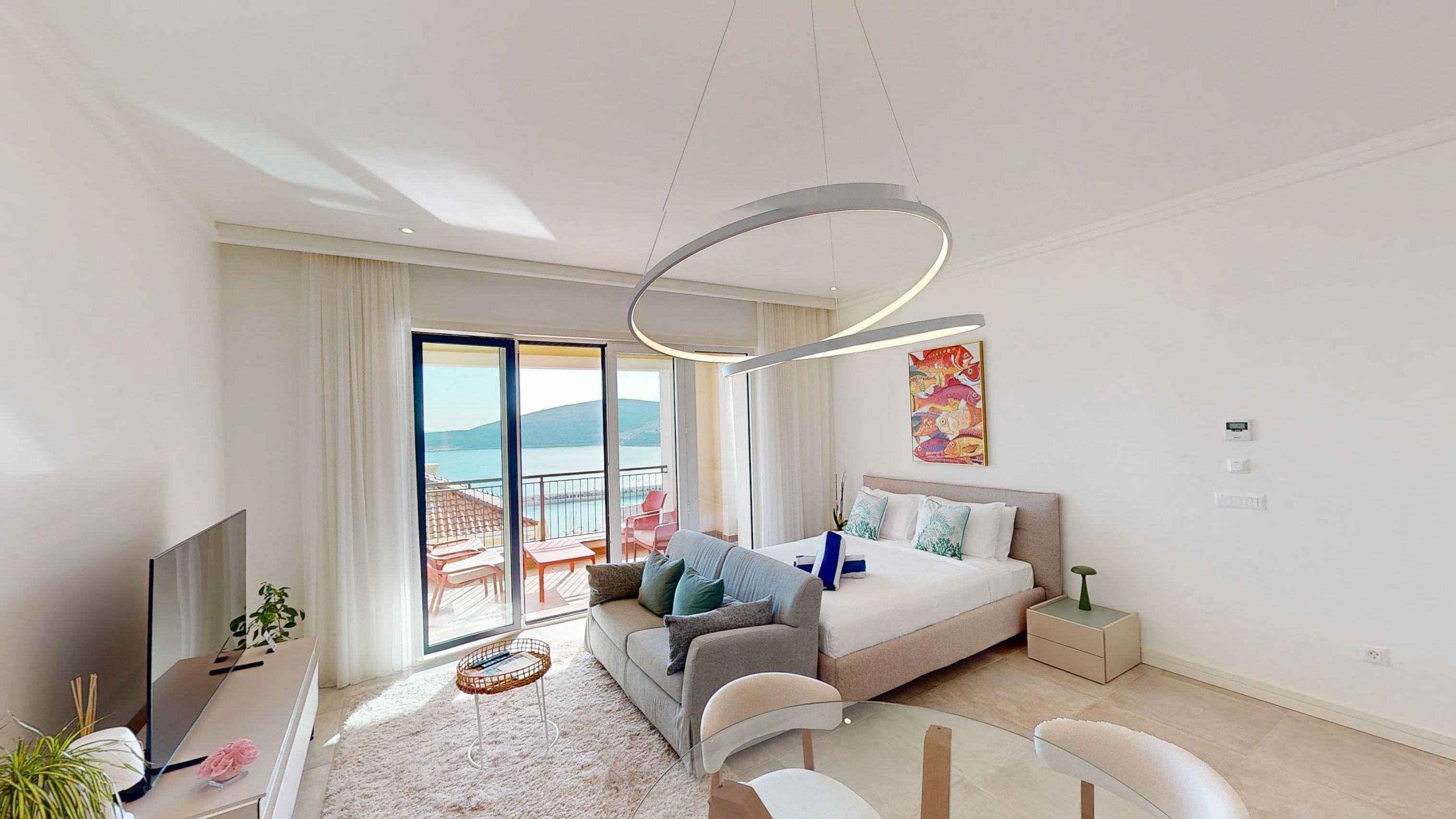 Open-plan studio living and sleeping area opening to the sea-view terrace at Studio I102 in Marina Village, Luštica Bay