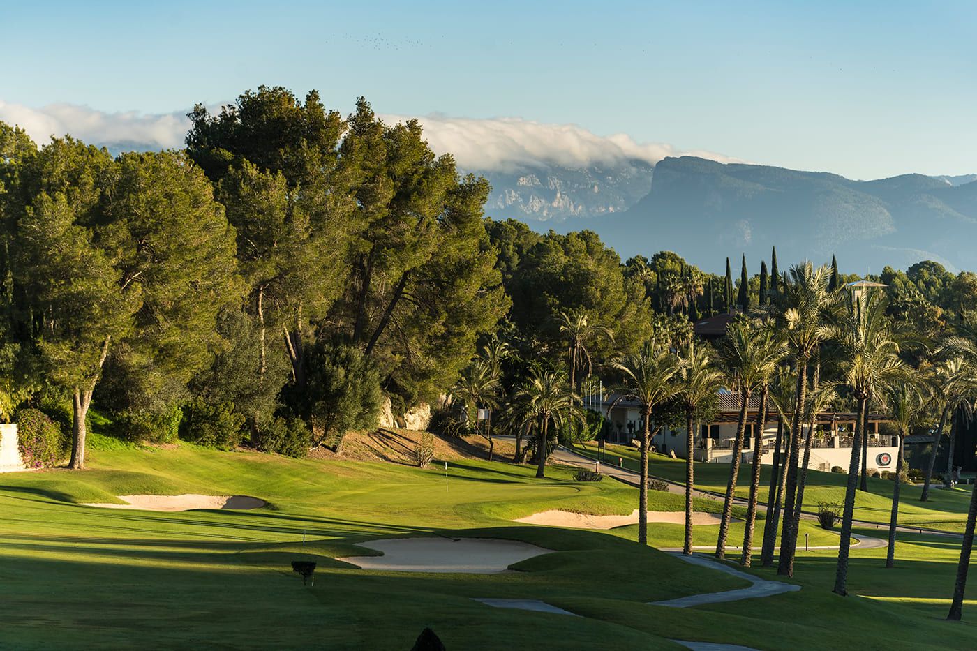 Golf Son Vida framed by mature trees and the Tramuntana foothills.