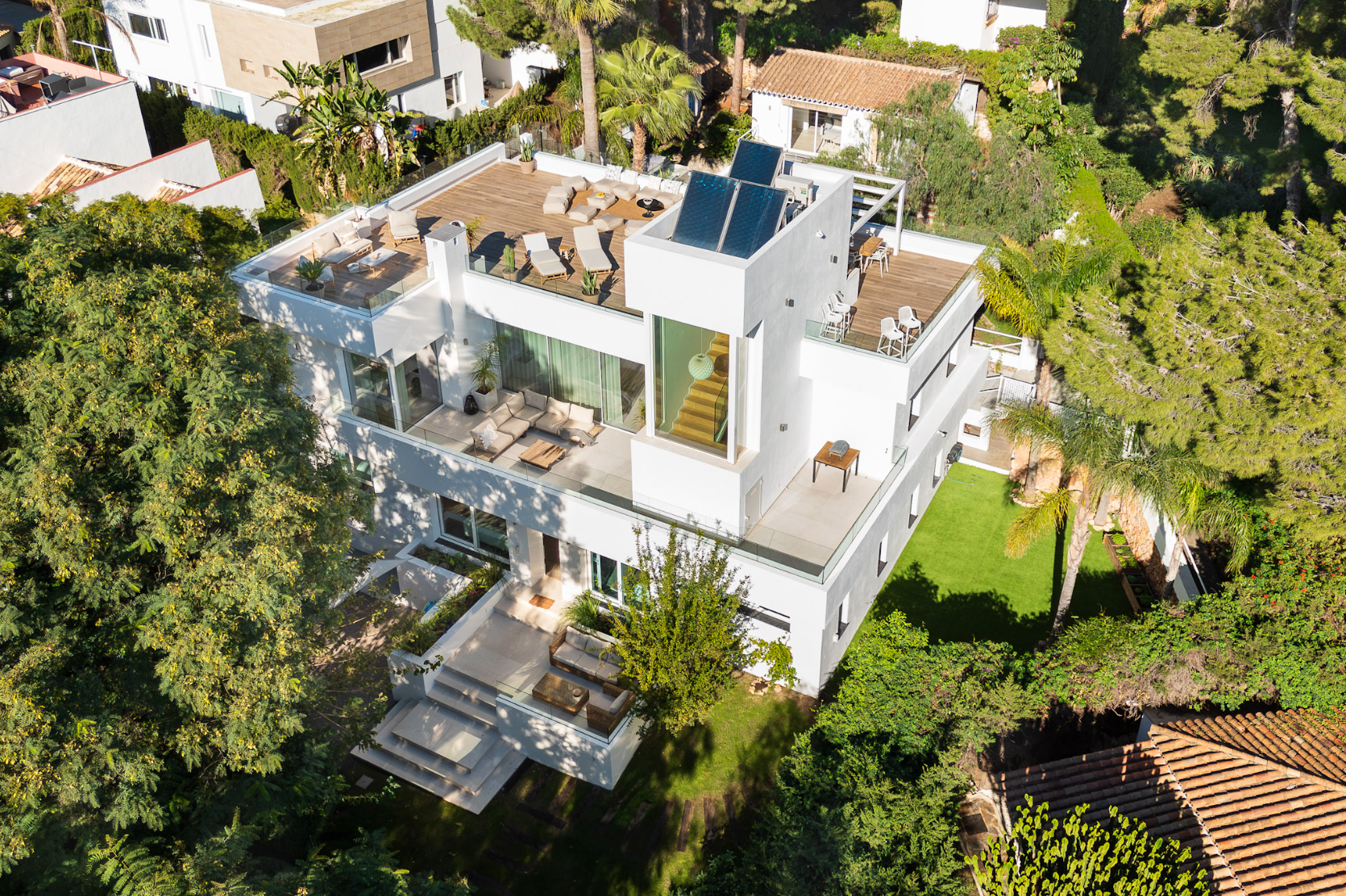Aerial view of the white contemporary villa, rooftop terrace and surrounding mature garden