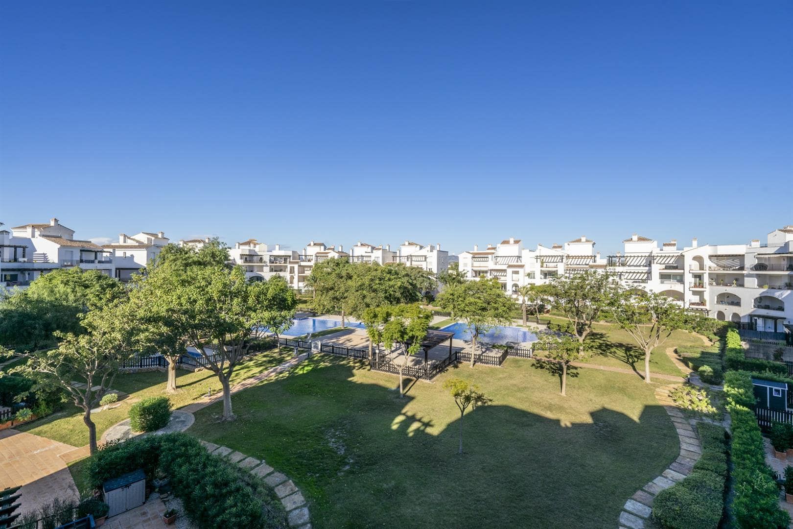 Elevated view across landscaped communal gardens and surrounding apartments.