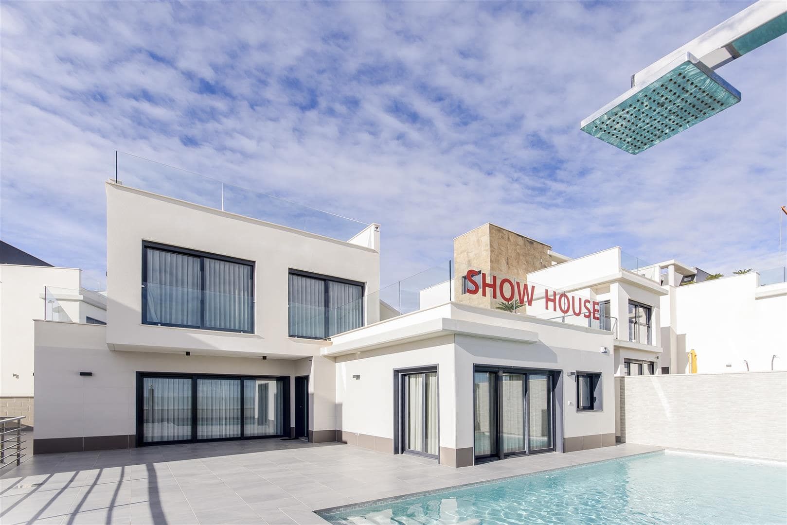 Daylight view of a white two-storey show home beside a swimming pool