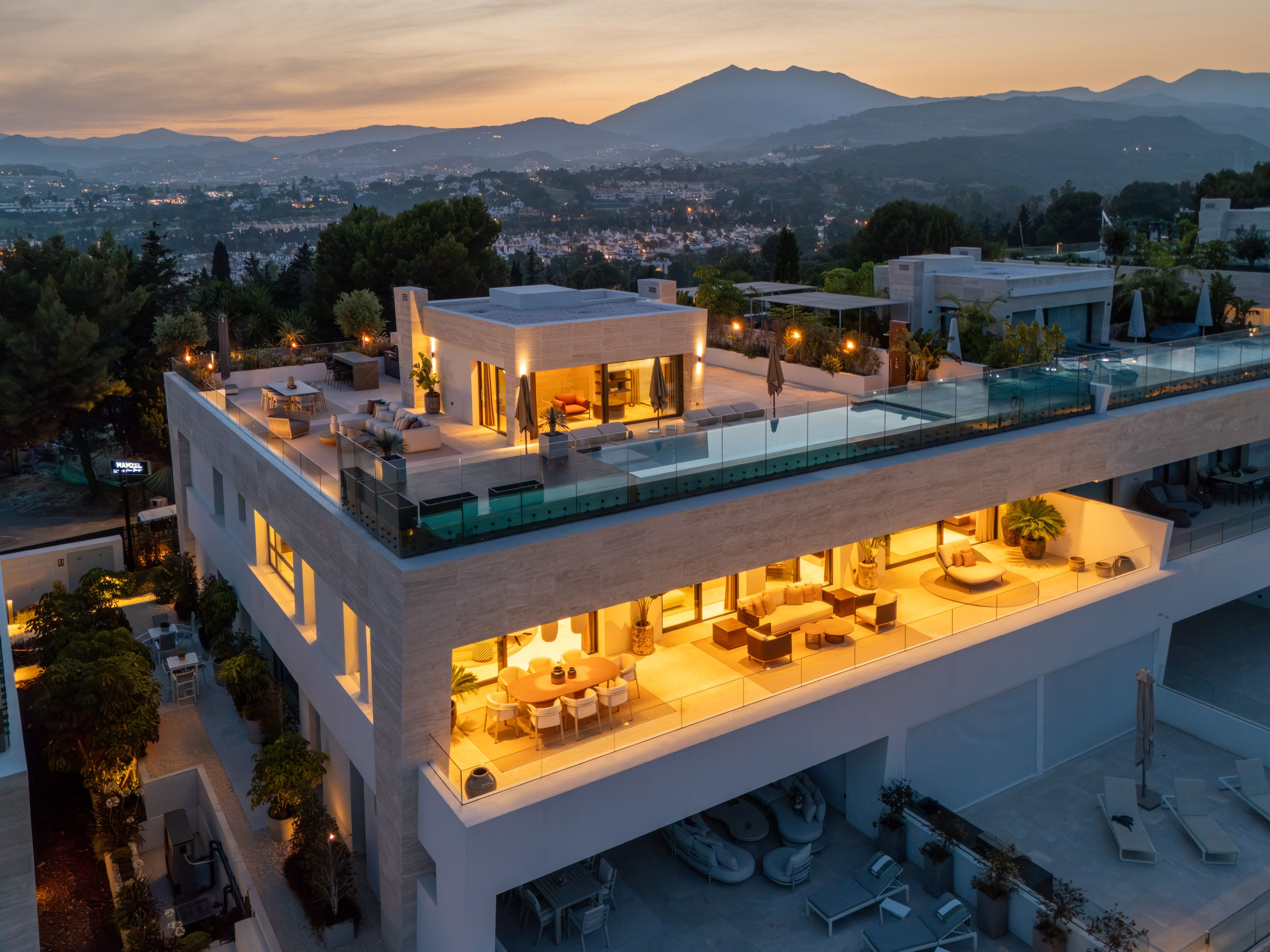 Elevated dusk view of SkyVilla 6 with illuminated rooftop terrace and pool.
