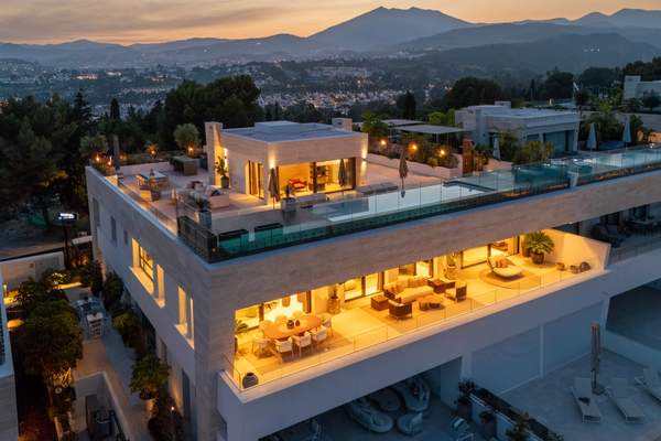 Elevated dusk view of SkyVilla 6 with illuminated rooftop terrace and pool.
