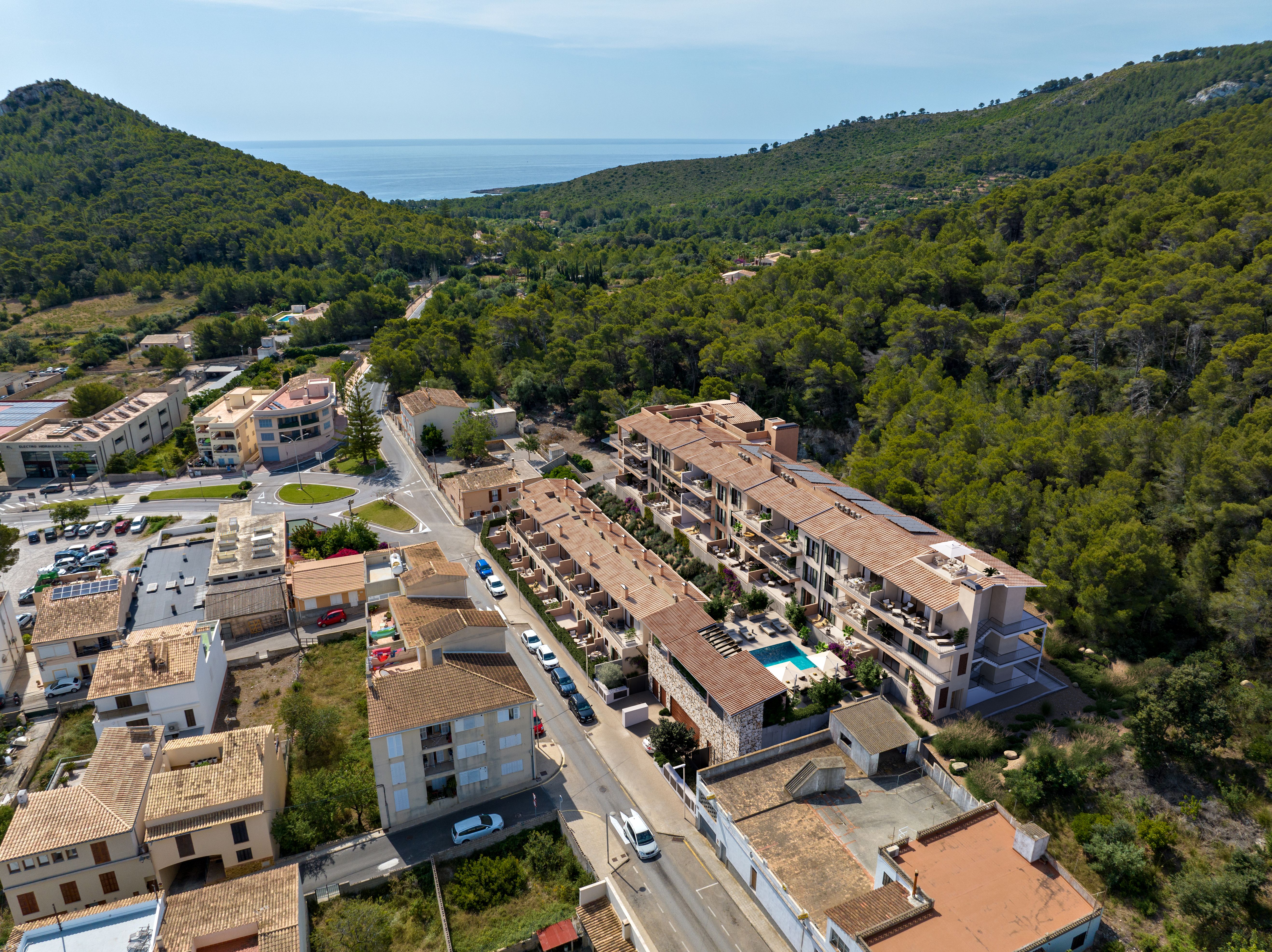 Aerial CGI view of OLIU in its wooded Capdepera setting with the sea beyond