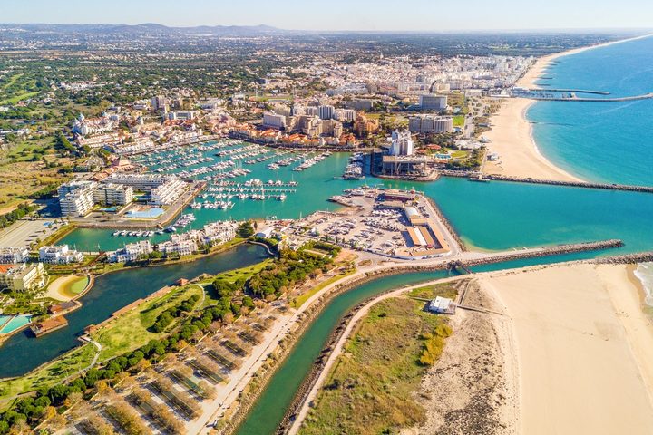 Aerial view of Vilamoura Marina, the beach and the Algarve coastline, with the town and green countryside behind