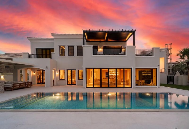 Rear exterior of Lime Tree Valley villa at dusk with illuminated pool