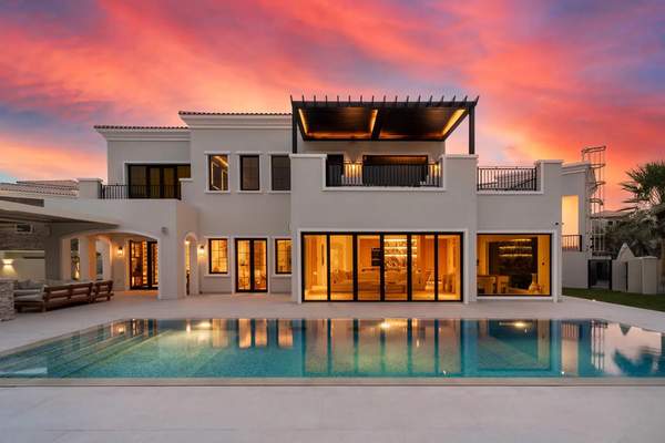 Rear exterior of Lime Tree Valley villa at dusk with illuminated pool