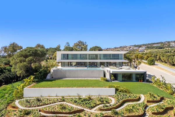 Elevated view of Villa Aldebaran with its glazed elevation, lawn and landscaped lower garden.