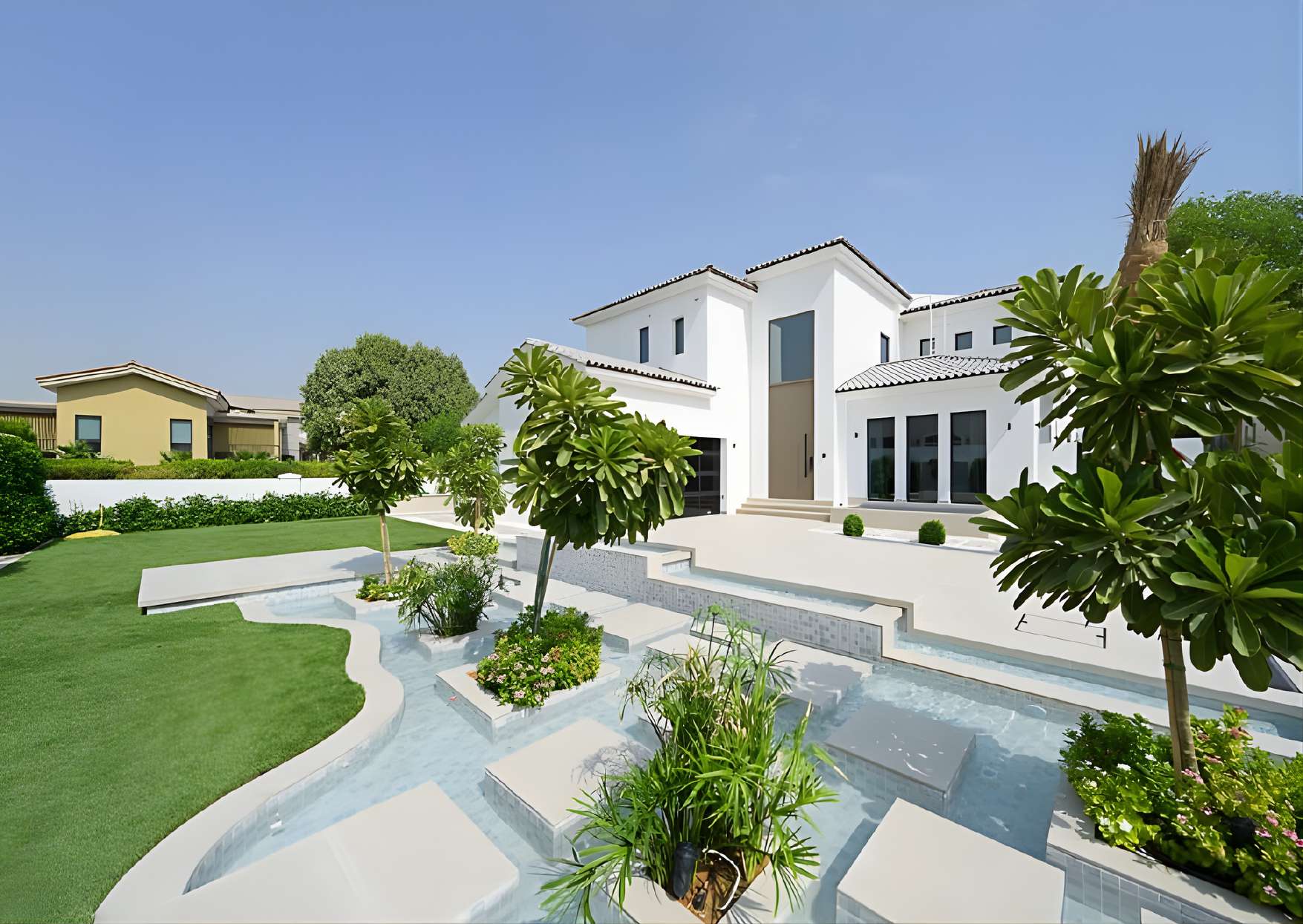 Front exterior of The Sundials villa with landscaped garden and water feature
