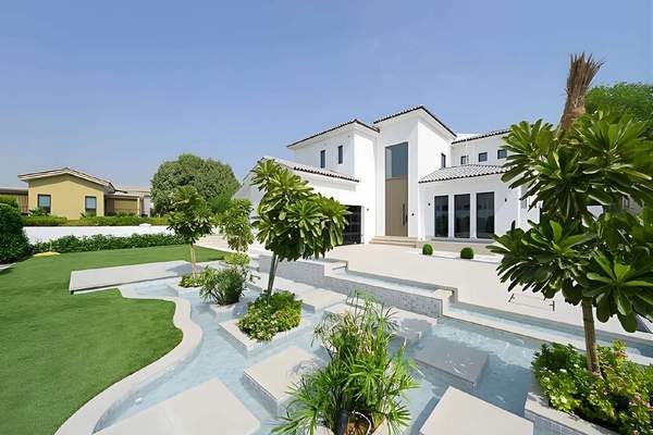 Front exterior of The Sundials villa with landscaped garden and water feature