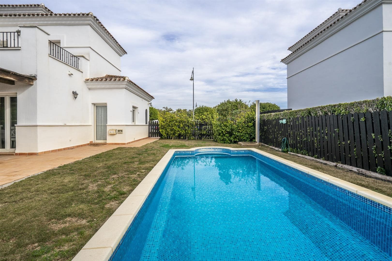 Poolside view of the villa and surrounding garden