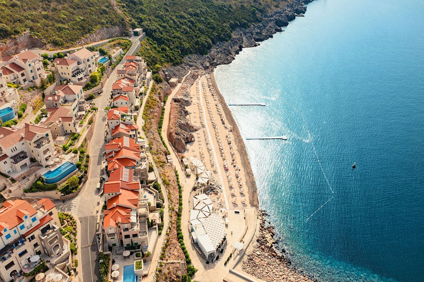 Aerial photograph of Marina Village residences and a beach beside the Adriatic at Luštica Bay