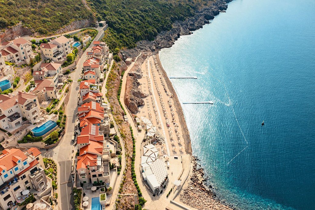 Aerial photograph of Marina Village residences and a beach beside the Adriatic at Luštica Bay