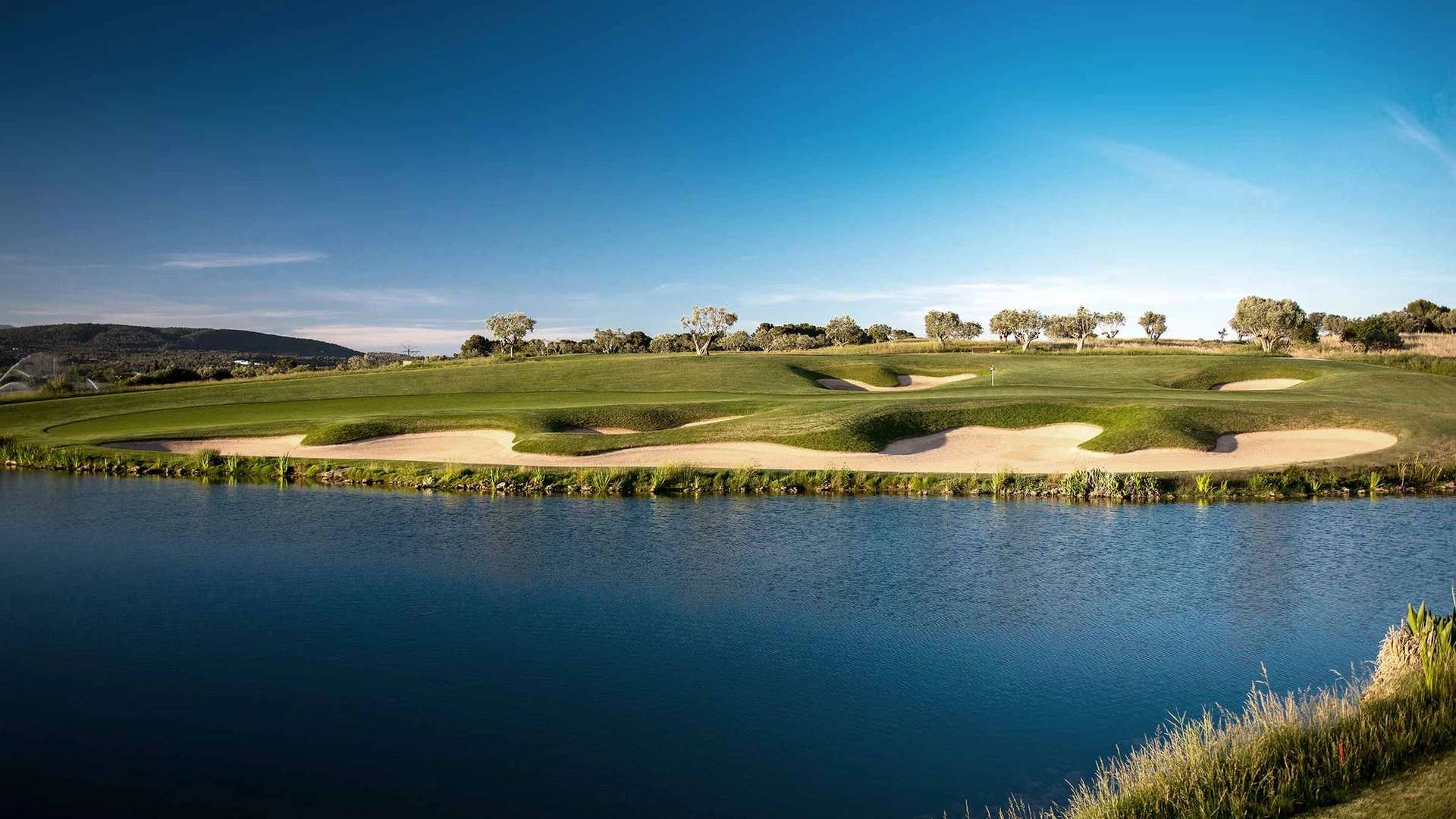 The water hazard, green and surrounding bunkers on the 17th hole at Golf Son Gual.