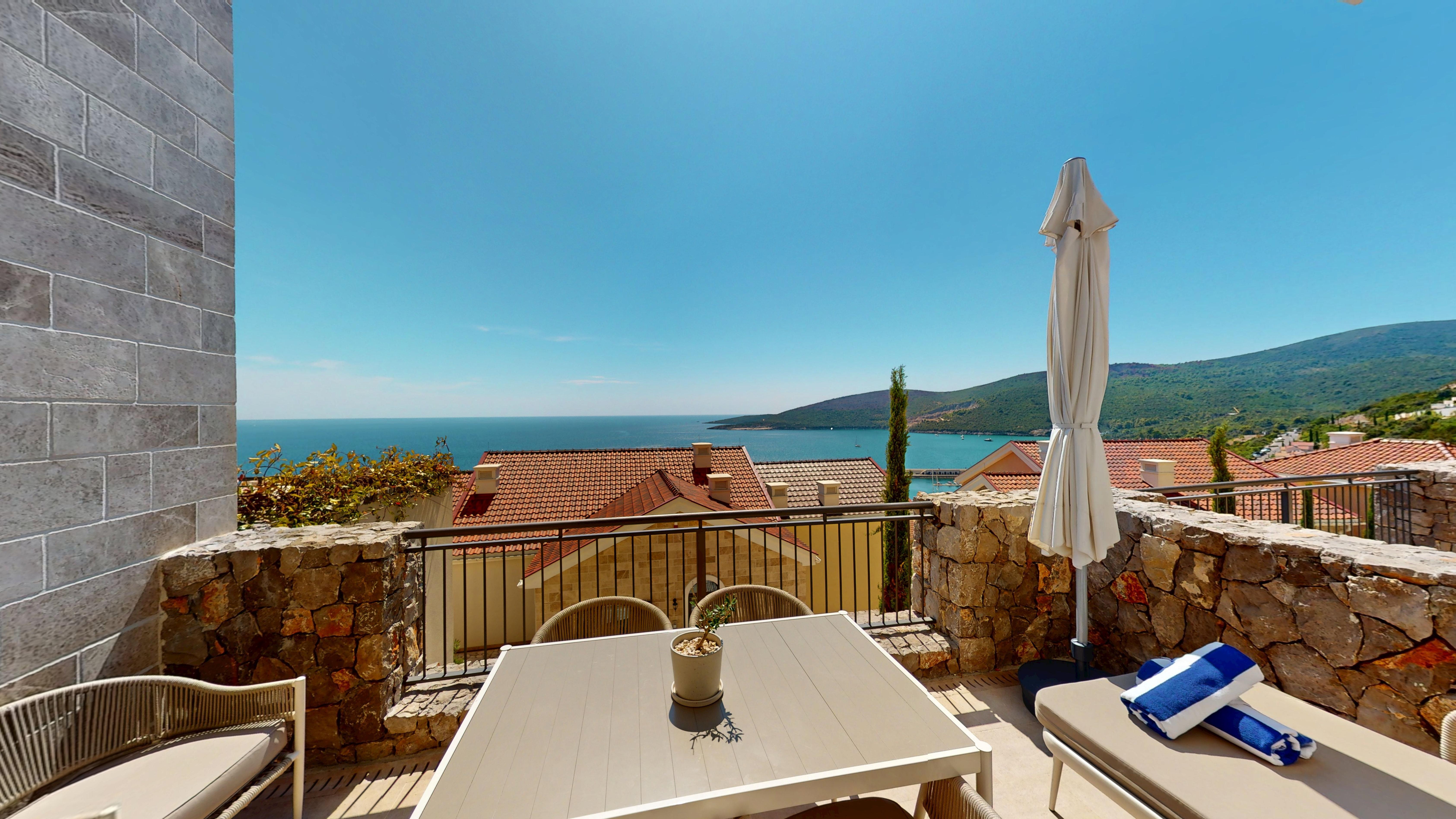 Private terrace with dining and lounging space overlooking the bay at Studio I202 in Marina Village, Luštica Bay