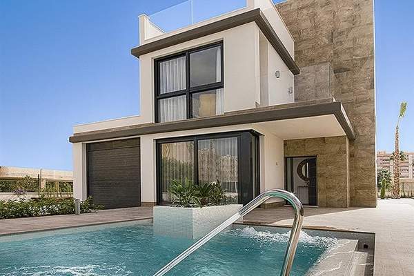 Photograph across a swimming pool towards a contemporary two-storey villa in daylight