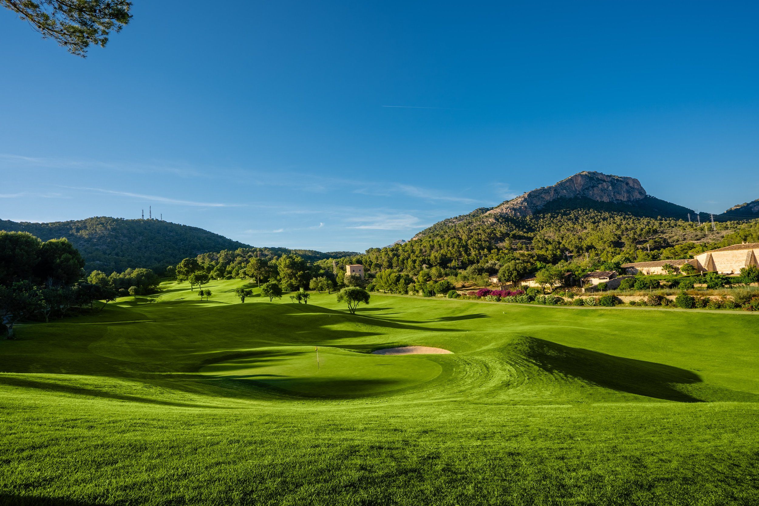 A fairway and green at Golf de Andratx with the surrounding hills beyond.