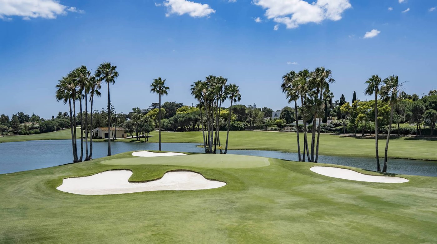 Green, bunkers, lake and palms at Real Club de Golf Sotogrande