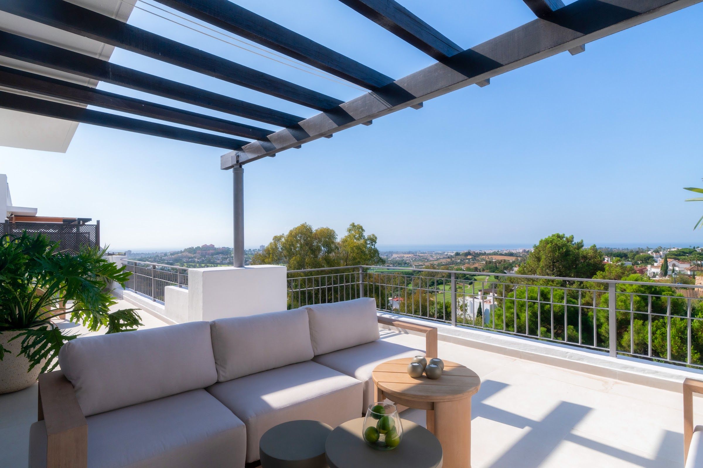 Private roof terrace lounge with panoramic sea and golf-valley views at La Quinta Greens