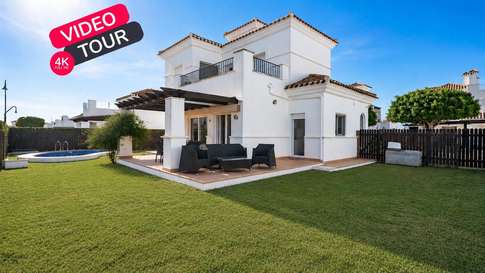 Rear exterior with lawn, covered terrace seating and a VIDEO TOUR 4K graphic.
