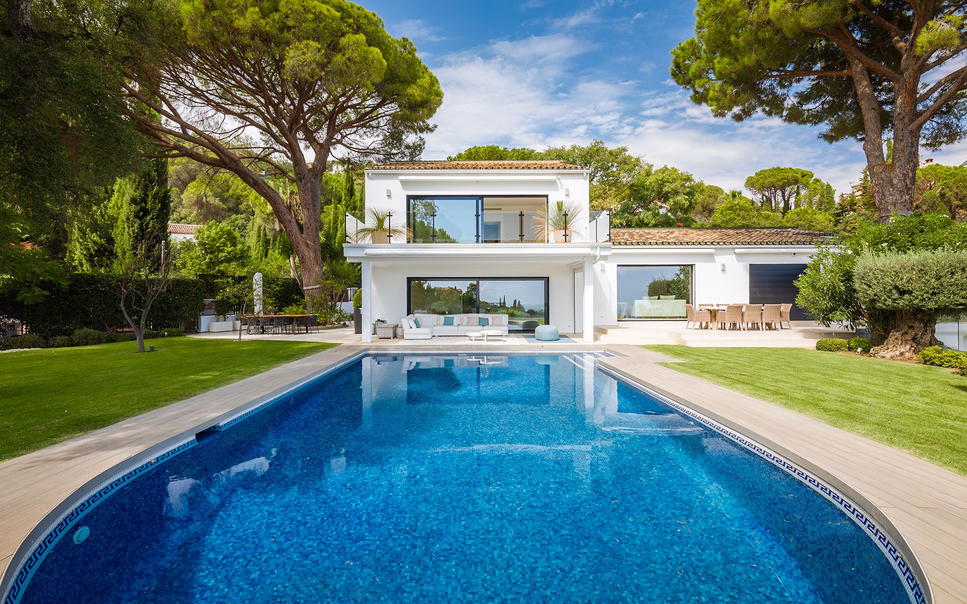 Front exterior of the El Madronal villa across the swimming pool and lawn.