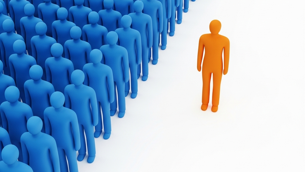 A large group of generic blue human figures standing together on the left, with a single bright orange human figure standing alone on the right, separated by a wide white path.