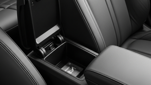 A detailed view of a modern car's center console with the storage bin and armrest inside the front cabin.