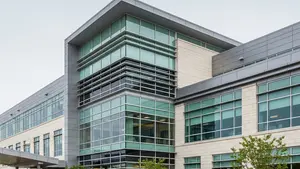 A modern healthcare facility building with large windows and a clean architectural design, representing a professional medical environment.