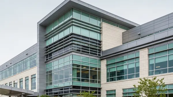 A modern healthcare facility building with large windows and a clean architectural design, representing a professional medical environment.