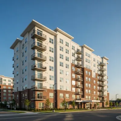 A modern high-rise senior living apartment building with balcony railings and windows viewed from street level during a clear day.