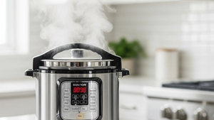 A stainless steel electric pressure cooker sitting on a kitchen counter with steam visible, representing a consumer product safety scenario.
