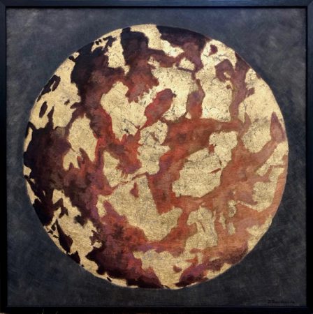 A planet in earth tones with golden veins.
