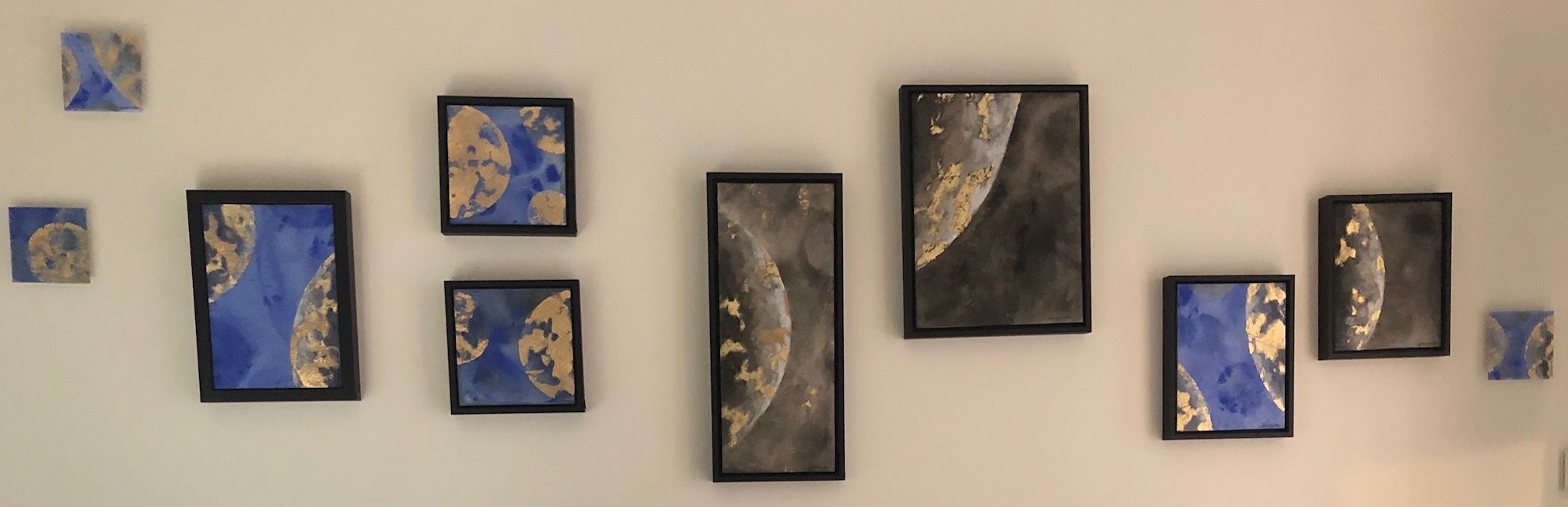 The full width of the wall, the small works in a row beside the large painting.