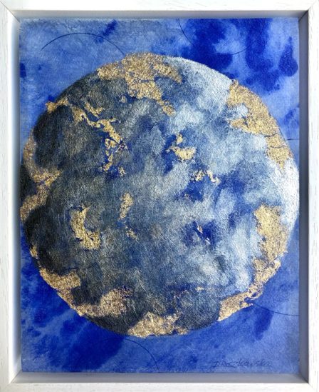 A moon in blue and silver with gold at its edges, in a white frame.