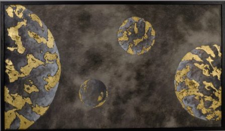 Four moons of different sizes in gold and grey, spread across a wide dark field.
