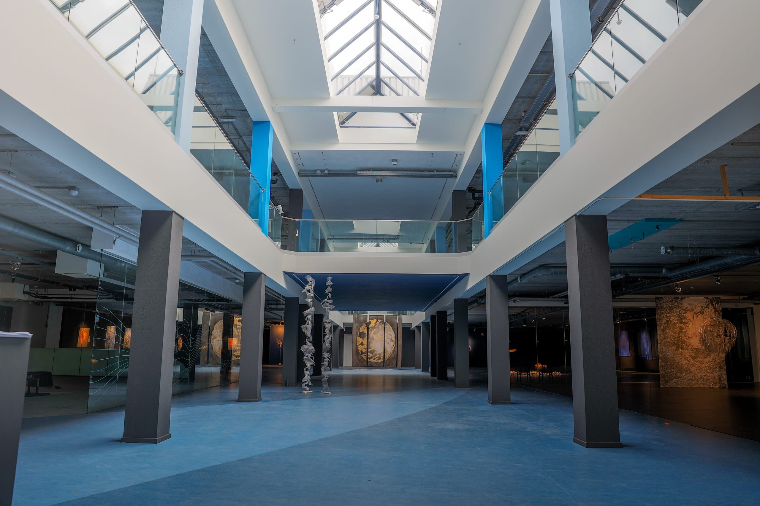 The hall of the former town hall, daylight from the roof, work by several artists.